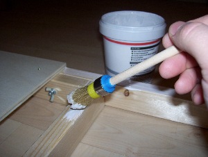 Holzleim auf dem Rahmen streichen